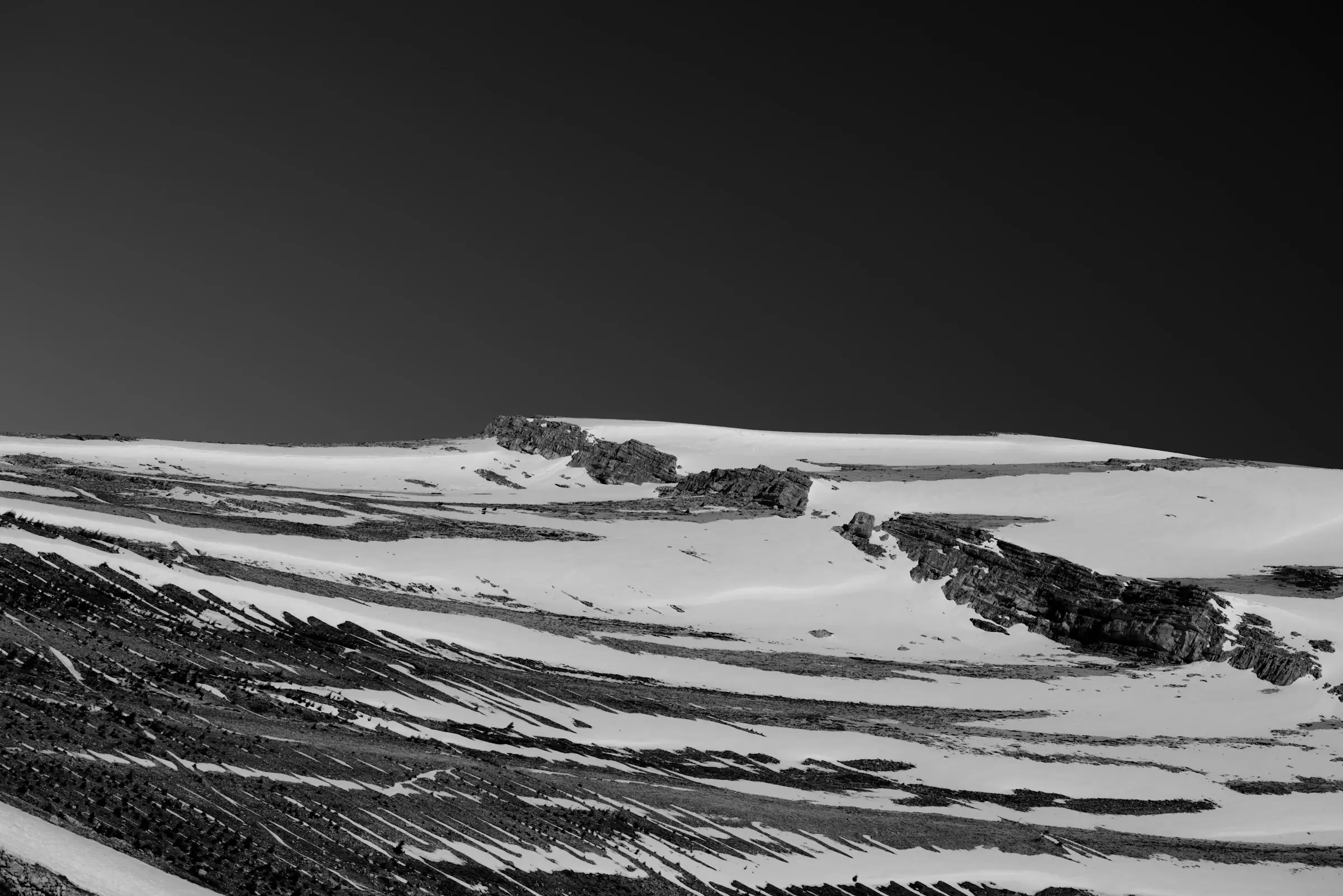 A snowy ridge under a near-black sky.